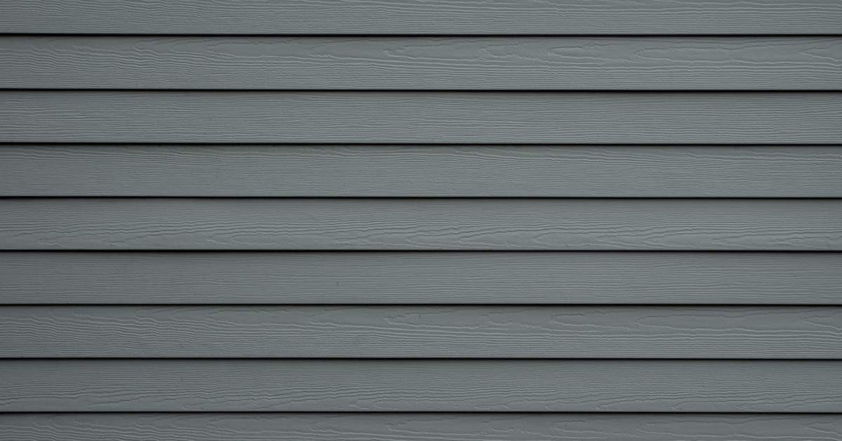 A close-up view shows a dark-gray siding attached to a home. The siding has many grooves and no cracks.